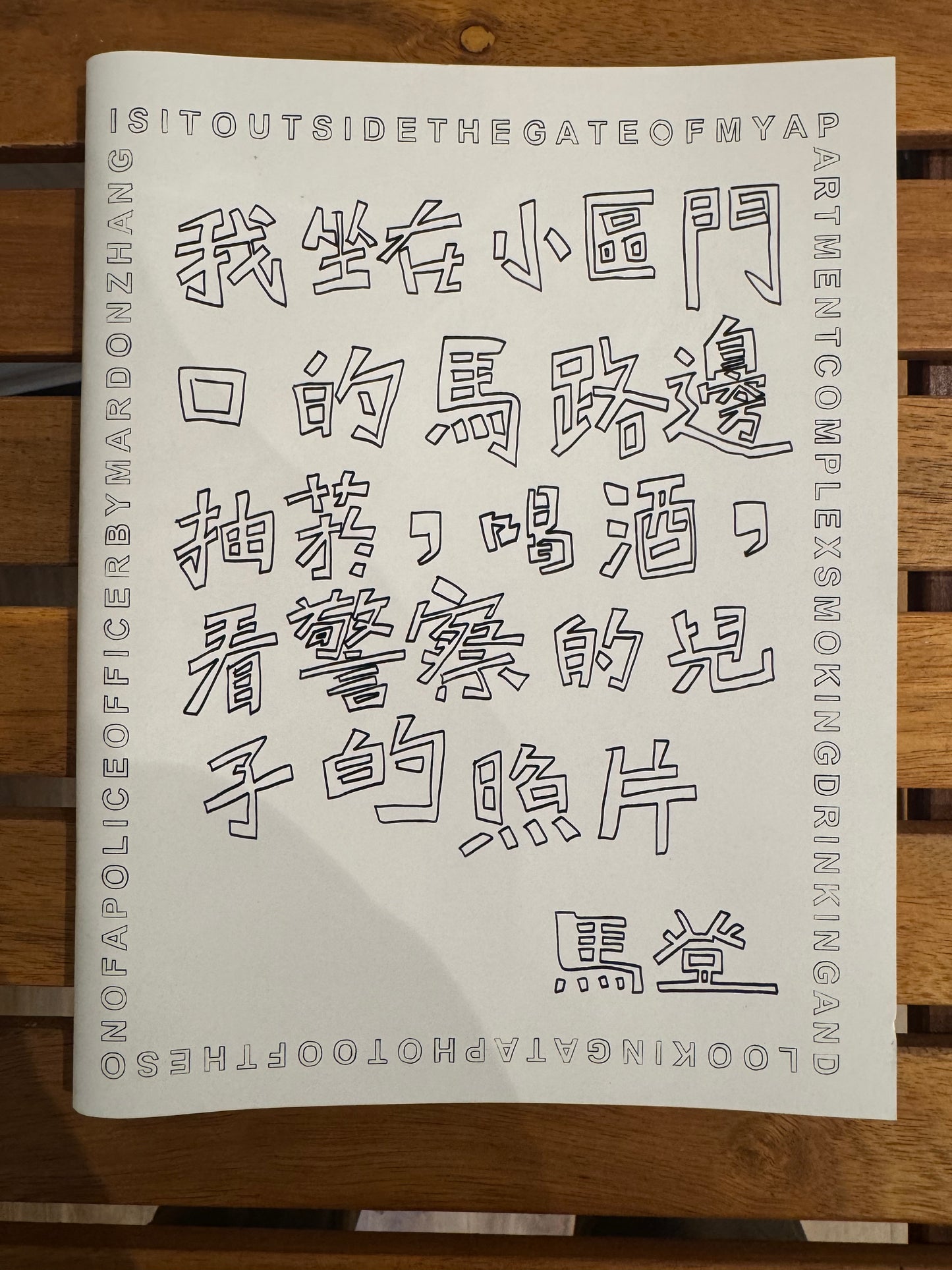 我坐在小區門口的馬路邊，抽菸，喝酒，看警察的兒子的照片